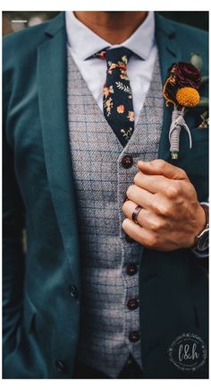 a man wearing a suit and tie with a boutonniere on his lapel