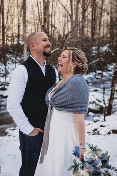 a bride and groom laughing together in the snow at their winter elopement wedding