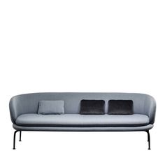 a gray couch with three pillows on it's back and two black cushions on the front