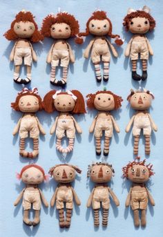 many dolls are arranged in rows on a blue surface