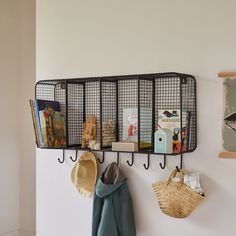 a coat rack with hats, books and other items hanging from it's hooks