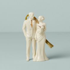 a wedding cake topper with a bride and groom figurine next to each other