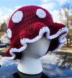 a red and white hat on top of a head mannequin's head