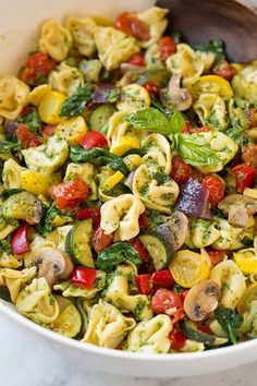 a white bowl filled with pasta and vegetables