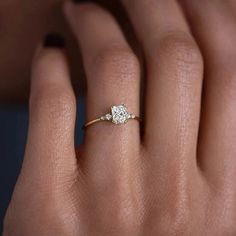 a woman's hand with a diamond ring on it