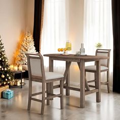 a dining table with two chairs next to a christmas tree