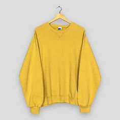 Vintage 90s Russell Athletic Yellow Mustard Sweatshirt Large Russell Athletic Yellow Plain Sweater Russell Made In Usa Blank Crewneck Size L Good Used Condition. Have minor stains, REFER PICTURE. Size (On Tag) : Size L **To make sure if it FITS YOU, refer at the exact measurements. Size Measurement (All measurements were taken lying flat) : Width [armpit to armpit] : 23.5 inches / 60 cm Length [shoulder to end of garment] : 26.5 inches / 67 cm THIS IS USED CLOTHING! PLEASE DON`T EXPECTED IT TO B 90s Style Crew Neck Top For Fall, Retro Crew Neck Tops For Fall, Vintage Crew Neck Winter Top, Vintage Crew Top For Winter, Vintage Crew Neck Top For Winter, Vintage Winter Crew Neck Top, Yellow Vintage Winter Tops, Yellow Vintage Tops For Winter, 90s Crew Top With Ribbed Cuffs