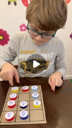 a young boy is playing with a board game