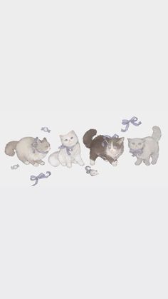 a group of cats standing next to each other on top of a white surface with blue ribbons