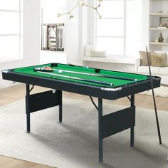 a pool table in the middle of a living room with white walls and flooring