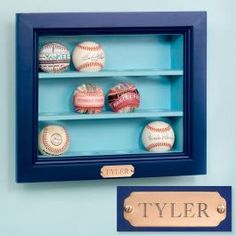 baseballs are displayed in a shadow box with a name tag on the bottom shelf