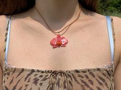 a close up of a woman wearing a necklace with a butterfly pendant on it's neck