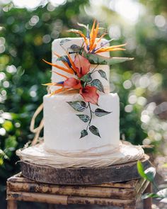 a wedding cake decorated with flowers and leaves