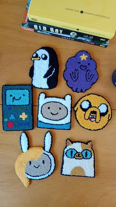 several embroidered patches are sitting on a table next to a computer mouse and bookcase