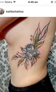 a woman's stomach with a flower tattoo on her side and the bottom part of her lower back