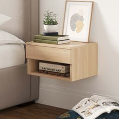 a book shelf with books on top of it next to a bed and a plant