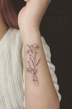 a woman's arm with a flower tattoo on the left side of her arm