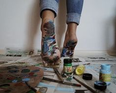 a person with lots of tattoos on their arms and legs is painting some art work