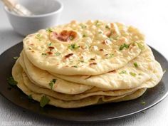 a stack of pita bread on a black plate