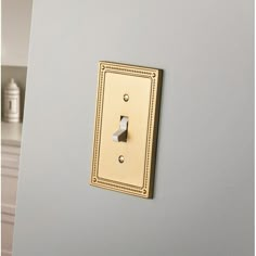 a light switch on the side of a wall in a room with gray walls and white trim