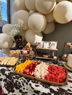 a table topped with lots of desserts and balloons in the shape of white balls