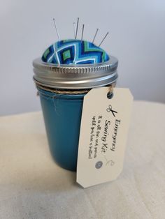 a blue jar with some pins in it