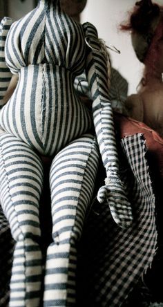 a striped stuffed animal sitting on top of a bed