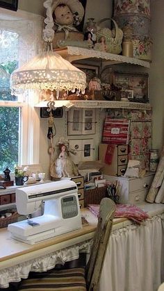 a sewing machine sitting on top of a white table next to a lamp and window