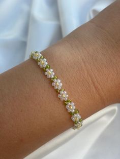 a close up of a person wearing a bracelet with flowers on it's arm