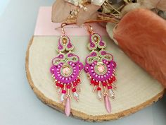 Add a touch of bohemian glamour to any ensemble with these exquisite handmade earrings. Featuring big beaded chandeliers in shades of gold and fuchsia pink, these unique earrings are sure to turn heads. Crafted with love and attention to detail, they make the perfect birthday gift for her. The fabric earrings are adorned with a stunning combination of gold and crystal beads, adding a hint of sparkle and elegance. Whether you're looking to dress up an outfit or make a statement, these bohemian ea Bohemian Glamour, Beaded Chandelier Earrings, Unique Birthday Gift, Fabric Earrings, Unique Birthday, Gold And Pink, Beaded Chandelier, Small Gift Boxes, Shades Of Gold