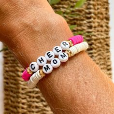 For all my cheer moms! Create your own custom stackable bracelet in your team colors or your personal favorite color combo.  This listing is for two bracelets. Select the color beads and make sure you write the SIZE and either GOLD or BLACK letter beads in the personalization box.  To determine size take a flexible measuring tape or string and measure around your wrist. Then add .5" to get your bracelet size. The most common size is Medium Adult 6.75"  Bracelet is made with elastic (stretchy) cord, 6mm heishi beads, gold plated (brass filled) disks and letter beads.  Please note that all sales are FINAL.  Excited to help you with your bracelet stacks! Be sure to message me with any questions!  Thank you for supporting my small business. White Casual Beaded Bracelets For Mother's Day, White Casual Stretch Bracelet For Mother's Day, Casual White Beaded Bracelets For Mother's Day, Casual White Stretch Bracelet For Mother's Day, Personalized White Heishi Beads Friendship Bracelets, White Heishi Beads Name Bracelet For Friendship, White Stacked Stretch Bracelet As Gift, White Stacked Stretch Bracelet Gift, Adjustable White Stacked Stretch Bracelet