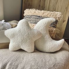 two white star pillows sitting on top of a bed