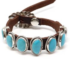 This incredible Navajo bracelet crafted by Danny Martinez is an extraordinary work of art. Seven turquoise stones of varying sizes, including a center stone and setting of 7/8" x 3/8", grace a stylish brown leather wristband closed with a sterling silver buckle. The buckle is adjustable, allowing this bracelet to comfortably fit wrists of up to 9" circumference. The image shows the exact item that you will receive. Western Leather Jewelry With Concho, Western Style Turquoise Leather Bracelets, Southwestern Brown Bracelets, Adjustable Turquoise Leather Bracelet With Concho, Adjustable Turquoise Western Bracelet, Adjustable Turquoise Cuff Bracelet With Concho, Turquoise Leather Concho Bracelets, Western Turquoise Bracelets With Concho, Western Turquoise Bracelet With Concho