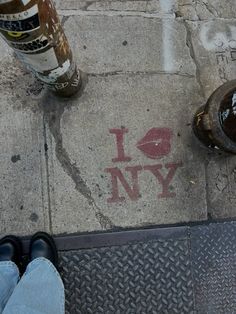 someone is standing on the sidewalk next to a fire hydrant and two empty bottles