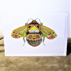 a card with a colorful insect on it