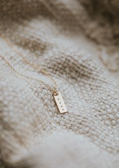 We updated our origina Mama Necklace to a shorter more modern bar design and added square pendant add-ons for the initials of your favorites. She’s still simple and minimal and full of very special meaning. Rectangle pendant measures 16mm long and is hand-stamped in a tiny uppercase block font. Bar is lightly brushed with steel wire for a matte finish. Our 6x9mm discs are hand-stamped with one heart or one initial per disc in an uppercase sans-serif font. Discs are suspended from a 16" or 18" de Classic Rectangular Charm Necklaces For Everyday, Everyday 14k Gold Rectangular Pendant Jewelry, 14k Gold Rectangular Pendant Jewelry For Everyday, 14k Gold Rectangular Pendant For Everyday Wear, Simple Rectangular Necklace For Gift, Elegant Personalized Necklace With Rectangular Links, Minimalist Box Chain Charm Necklaces For Everyday, Minimalist Box Chain Charm Necklace For Everyday, Everyday Personalized Square Pendant Jewelry