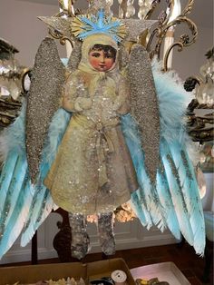 an angel figurine is hanging from a chandelier