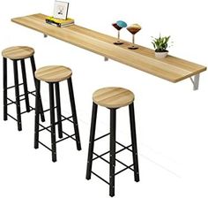 three stools and a table with a laptop on it