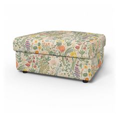 an upholstered footstool with colorful flowers and plants on the front, sitting against a white background