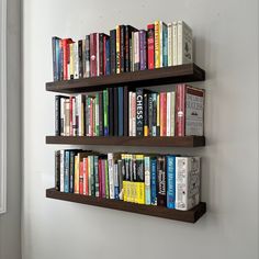 two wooden shelves filled with books on the wall