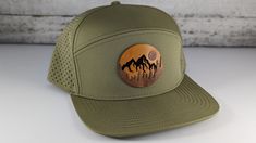 Mountain with moon wood on leather patch hat.  Made on a high quality perforated waterproof hat.  Through a painstaking process we have learned how to inlay wood and leather for a one-of-a-kind style hat. Impress your friends with the mountain landscape patch hat. -Product Care instructions-                      Hand wash only.   -Shipping and Production-                     We produce each item as made to order.  Currently our production and shipping time is 1-3 business days.  We also can ship Brown Flat Bill Snapback Hat For Hiking, Leather Baseball Cap With Short Brim For Outdoor, Leather Short Brim Baseball Cap For Outdoor, Outdoor Trucker Hat With Leather Patch And Short Brim, Leather Snapback Hat For Outdoor, Waxed Finish Outdoor Cap, Outdoor Hats With Leather Patch And Curved Brim, Outdoor Hats With Curved Brim And Leather Patch, Curved Brim Baseball Cap With Leather Patch For Outdoor