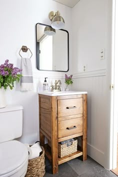 a bathroom with a sink, toilet and mirror