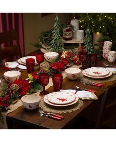 the table is set for christmas dinner with red and white dishes