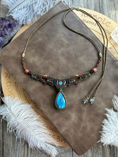 a necklace with a blue tear on it sitting on top of a piece of cloth