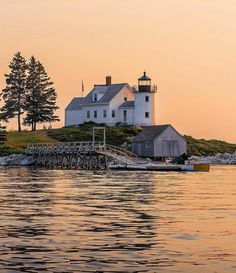 a white house sitting on top of a small island next to a body of water