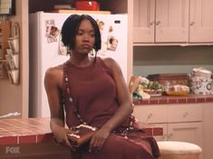 a woman sitting on top of a counter in a kitchen