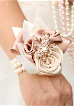 a close up of a person's hand wearing a wrist corsage