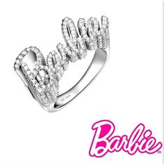 Elevate your style with our stunning 925 sterling silver Barbie ring. This exquisite piece features the word “Barbie” elegantly crafted in sparkling gemstones, creating a dazzling and glamorous accessory perfect for any fashion-forward individual. The ring’s intricate design and shimmering details make it a standout piece in any jewelry collection. Shipping:Takes 5-8 business days depending on stock, these beautiful rings are custom sized and made in small batches. If your size is in stock this item will ship immediately Product Details: Material: 925 Sterling Silver Gemstones: Clear Cubic Zirconia Design: Sparkling “Barbie” lettering Finish: Polished Size: Adjustable Occasion: Everyday wear, parties, and special occasions Why Choose This Ring? Elegance: The combination of sterling silver Luxury Party Diamond Ring With Sparkling Stones, Sparkling Sterling Silver Fine Jewelry Rings, Fine Jewelry Sterling Silver Sparkling Rings, Luxury Diamond Ring With Sparkling Stones For Party, Glamorous Party Diamond Ring With Accents, Glamorous Diamond Ring With Accents For Party, Glamorous Diamond Ring With Diamond Accents For Party, Sparkling Sterling Silver Rings In Fine Jewelry Style, Fine Jewelry Sterling Silver Rings With Sparkling Details