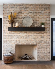 a living room with a brick fireplace and wooden floors