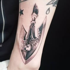 a tattoo with a knife and stars on the arm that is black and grey in color